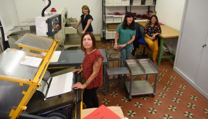 Foto di lavoratrici della stamperia davanti alle stampanti braille