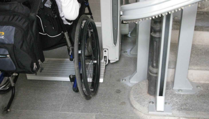 Foto di una carrozzina accanto a una scala elettrica per disabili